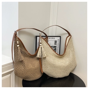 Detailed close-up of woven straw tote bags with long tassels and brown leather straps