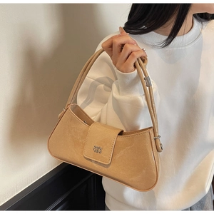 Détail du sac baguette beige montrant le logo GOJI BDW en métal poli et le rabat fermé
