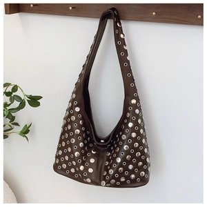 Détail des rivets en métal argenté et des œillets sur le sac hobo en cuir marron foncé