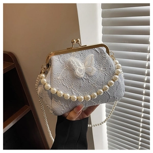 Detail of light blue pleated bag with butterfly embroidery and pearl handle