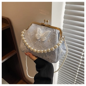 Detail of light blue jacquard bag with white butterfly embroidery and pearl handle