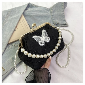 Detail of vintage black kiss lock bag with butterfly lace and pearl crossbody chains