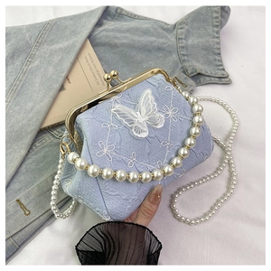Detailed view of light blue kiss-lock bag with lace butterfly motifs and pearl strap