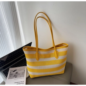 Detail der gelb-weiß gestreiften gewebten Tasche mit HAMIROO-Lederetikett und Trageriemen
