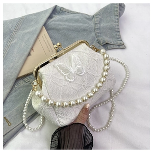 Detail of cream vintage pearl bag with 3D butterfly embroidery and gold metal clasp