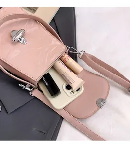 Détail du petit sac à bandoulière rose avec rabat marbré et fermoir rotatif en métal argenté
