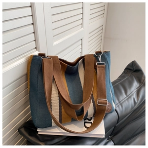 Detail of striped canvas tote with blue, yellow and white stripes and adjustable strap