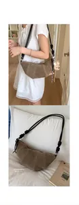 Brown suede crescent bag with knot strap and cute bear pendant on white pillow