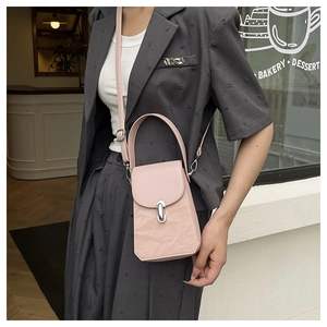 Détail du mini sac à main rose clair à texture plissée avec fermoir rotatif argenté