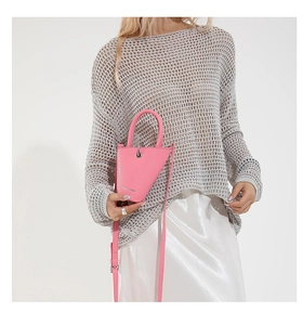Détail du sac seau triangulaire rose en cuir litchi avec bandoulière fine et élégante