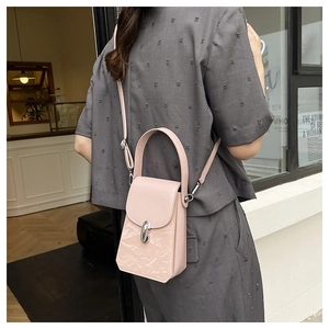 Détail du mini sac bandoulière rose clair avec fermoir argenté et texture en cuir