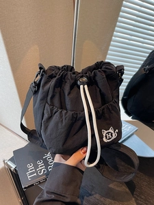 Black nylon bucket bag with cat embroidery and adjustable drawstring for daily commute