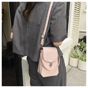 Vue détaillée du sac bandoulière rose avec fermoir rotatif argenté et coutures fines