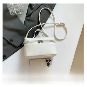 Detailed macro of white litchi grain leather texture and silver zipper of a shoulder bag