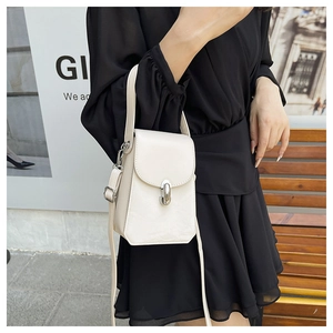 Détail du sac bandoulière blanc crème avec fermoir rotatif argenté sur robe noire