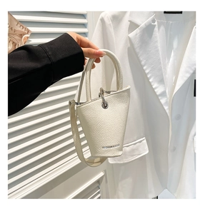 Détail du sac seau blanc crème avec texture en cuir grainé et boucle en métal