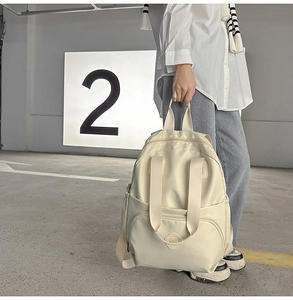 Makroaufnahme des cremefarbenen Nylon Rucksacks mit Fronttasche und eleganter Textur