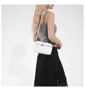 White box bag with lychee texture and silver hardware worn by a model in a grey top