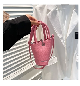 Détail du sac seau rose avec anneau en métal argenté et texture cuir grainé litchi