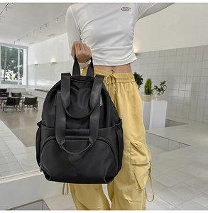 Detail eines schwarzen Nylon-Rucksacks mit vielen Taschen und stabilen Tragegriffen