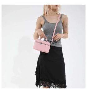 Détail du sac à main en cuir rose avec fermeture éclair argentée et bandoulière