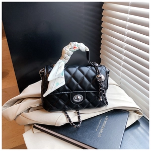 Detail of quilted leather crossbody bag with silver twist lock and floral silk scarf handle