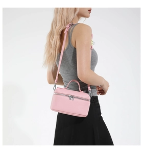 Detail view of pink lychee leather handbag with adjustable strap and metal zipper