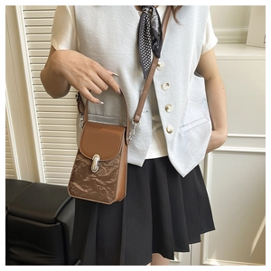 Détail du sac bandoulière marron foncé avec texture papier et boucle argentée