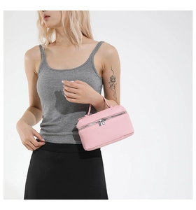 Détail d'un sac à main en cuir rose avec double fermeture éclair et poignée fine