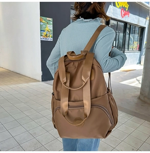 Street-View eines braunen wasserdichten Nylon-Rucksacks mit Seitentaschen und Griff