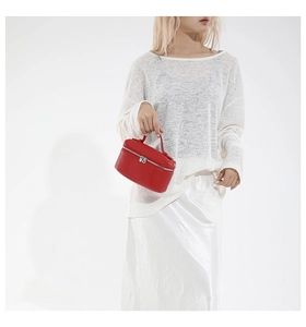 Detail of red pebbled leather mini bag with silver double zippers and smooth handle