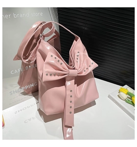 Detail der rosa Lackleder Handtasche mit großer Schleife und silbernen Metallnieten
