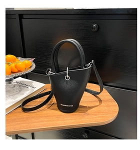 Détail du sac seau en cuir grainé avec finitions argentées et poignée fixe robuste