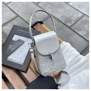 Détail du sac à rabat argenté avec texture marbrée et fermoir ovale en métal chic