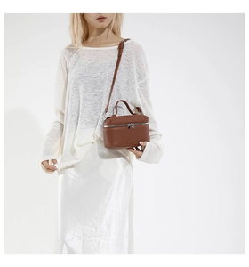 Detail view of dark brown pebbled leather crossbody bag with top handle and silver zipper