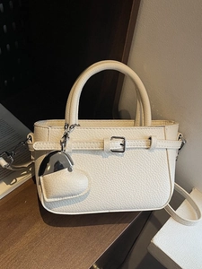 Chic beige lychee pattern leather crossbody bag with heart pendant on wooden surface