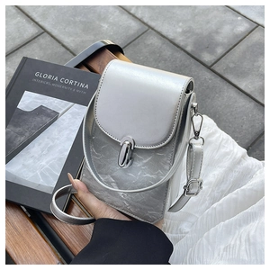 Détail du sac bandoulière argenté avec texture marbrée et fermoir rotatif en métal