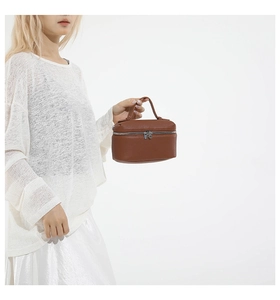 Detail of caramel brown litchi pattern mini handbag with curved handle and metal zipper