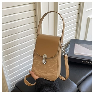 Détail du mini sac à bandoulière marron clair avec texture plissée et fermoir argenté