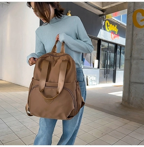 Detailansicht des großen braunen Nylon-Rucksacks mit Tragegriff und praktischen Seitentaschen