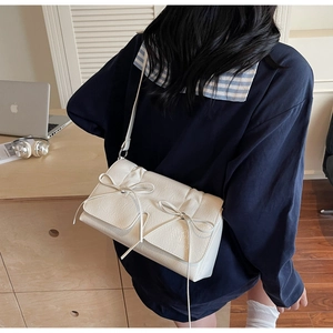 Détail du sac en similicuir blanc crème avec deux nœuds doux pour un style féminin