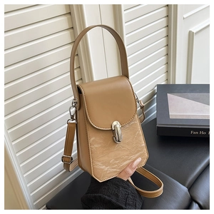 Détail du sac bandoulière marron clair avec texture plissée crème et boucle en métal argenté