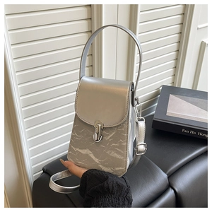 Détail du sac à main argenté à texture froissée avec fermoir métallique et fini brillant