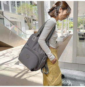 Details des dunkelgrauen Nylon-Rucksacks mit Seitentaschen und geräumigen Fächern