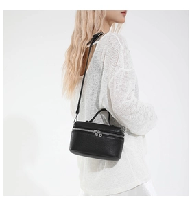 Détail du sac caméra en cuir noir grainé avec double fermeture éclair argentée et anse