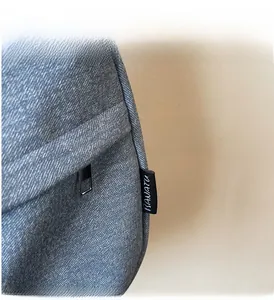 Detail view of blue denim hobo bag featuring stitching, metal zipper, and brand logo label