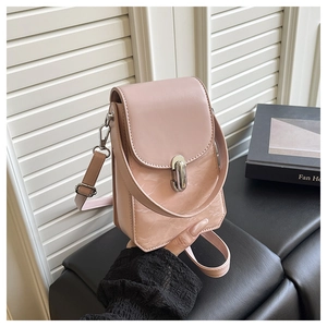 Gros plan du petit sac à bandoulière rose avec fermoir rotatif et texture cuir
