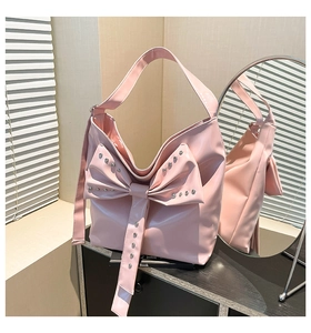 Nahaufnahme der rosa PU-Ledertasche mit großer Schleife und dekorativen Metallnieten