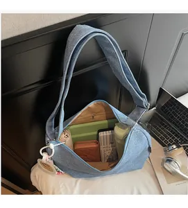 Spacious interior of blue denim tote bag holding tablet, umbrella and wallet