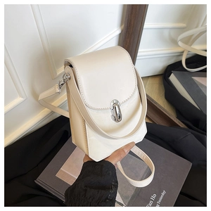 Gros plan du mini sac carré en cuir crème avec fermoir rotatif argenté et bandoulière